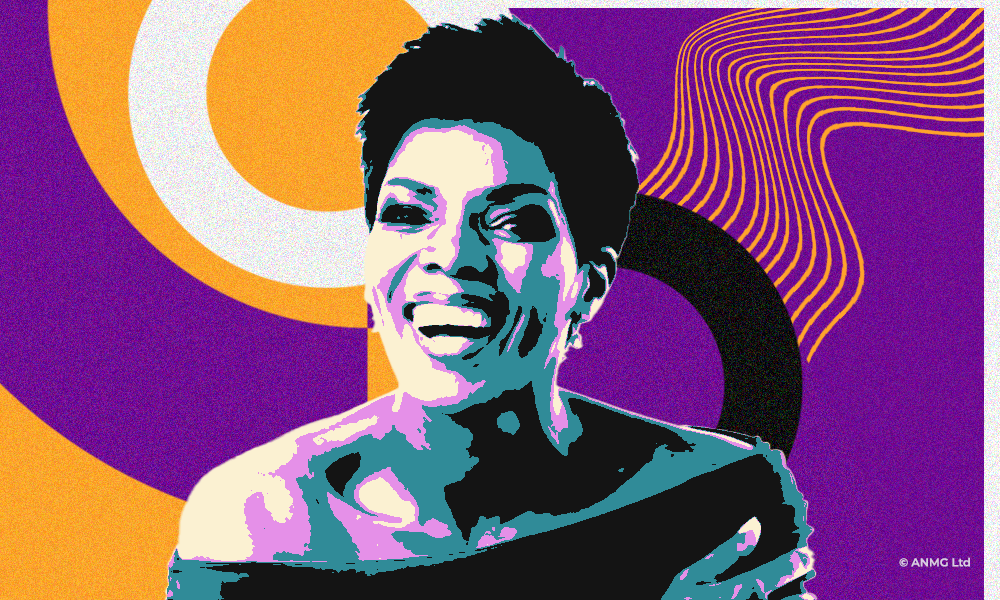 Connie Ferguson wearing off shoulder top - short hair - bold smile